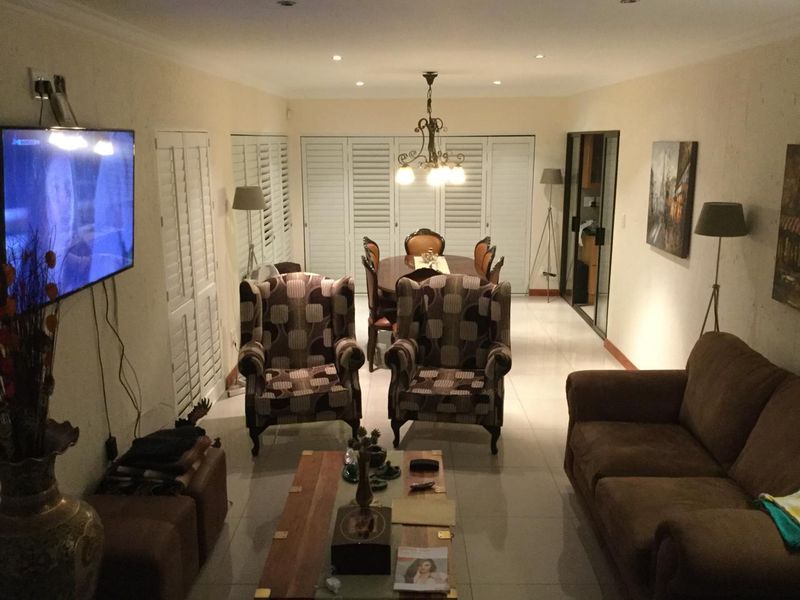 Open-plan living and dining area featuring tiled flooring, recessed lighting, and plantation shutters, providing a functional and connected space for daily living.