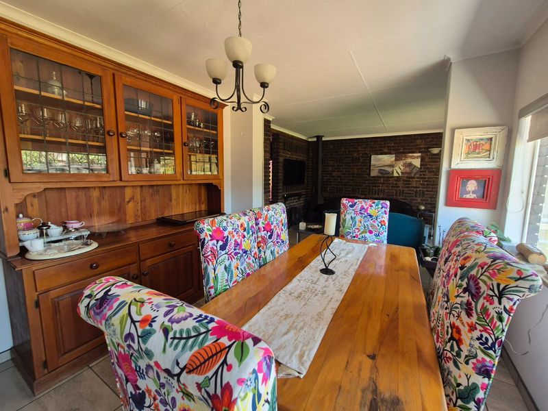 Dining room featuring a built-in wooden hutch, exposed brick wall, and tiled flooring, offering a warm and traditional aesthetic.