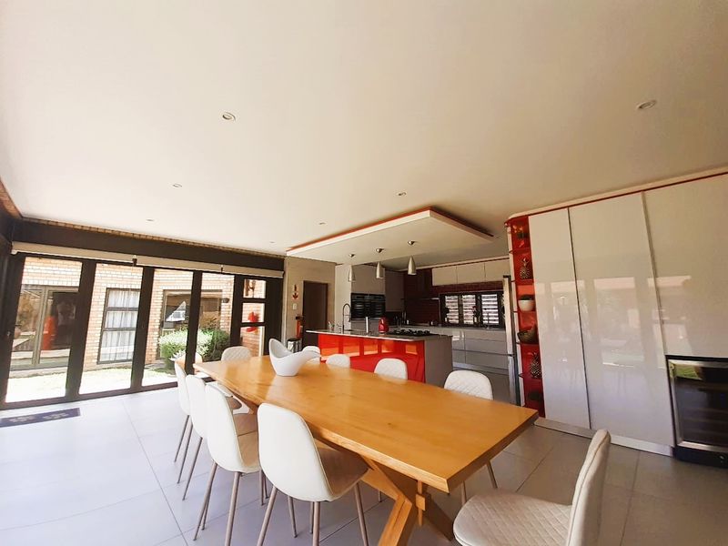 Spacious open-plan kitchen and dining area featuring modern cabinetry, a central island, and large sliding doors providing seamless access to the outdoor space.
