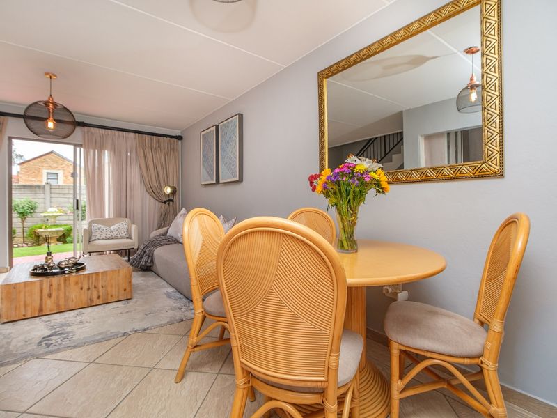 Open-plan living and dining area featuring tiled flooring and a sliding glass door providing direct access to the rear garden.