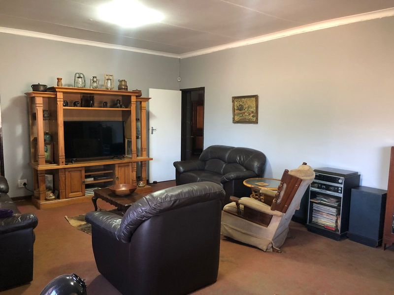 A spacious living room featuring neutral wall finishes and classic cove cornicing, providing a functional and comfortable area for relaxation.