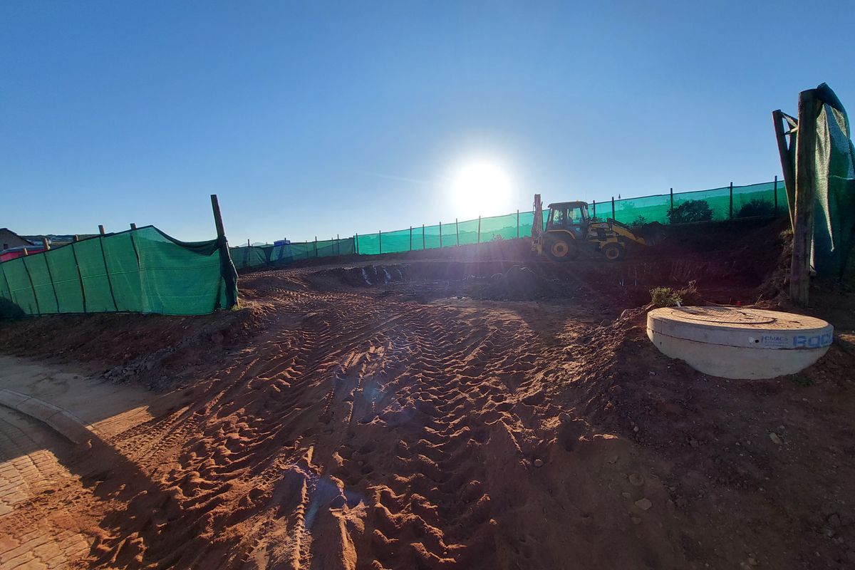A vacant plot of land currently undergoing excavation and site preparation for future development.