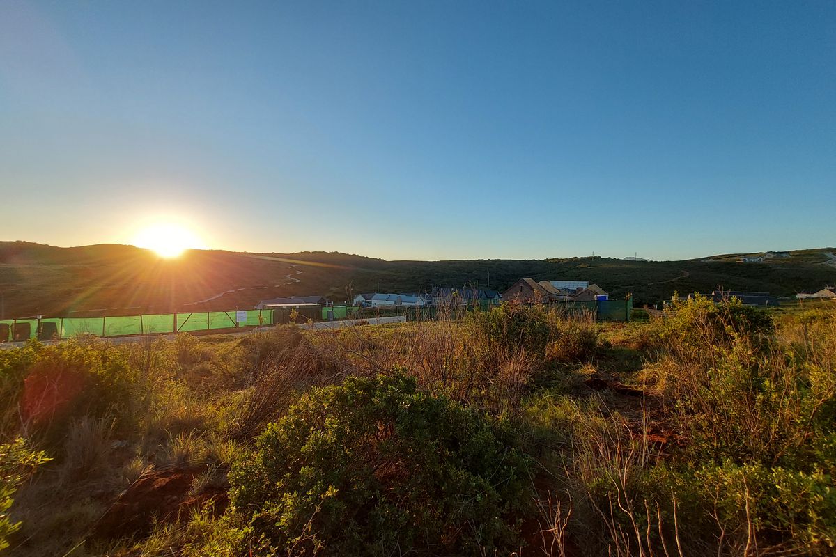 A scenic landscape view of the surrounding hills and horizon at sunset, showcasing the natural environment and local terrain.