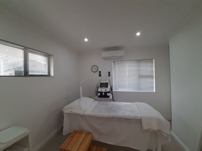 A clean, well-maintained office or treatment room featuring recessed lighting, split-system air conditioning, and venetian blinds for adjustable natural light.
