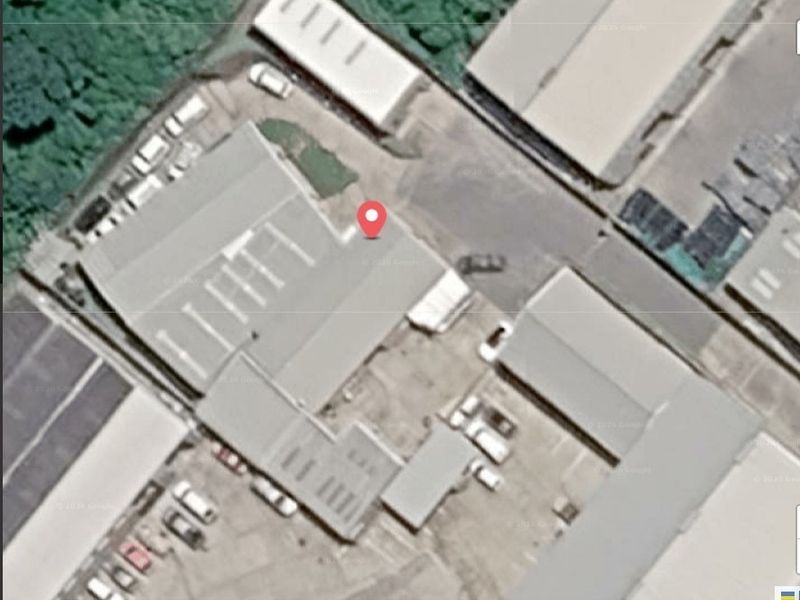 Aerial view of an industrial property featuring warehouse buildings, paved yard space, and designated parking areas.