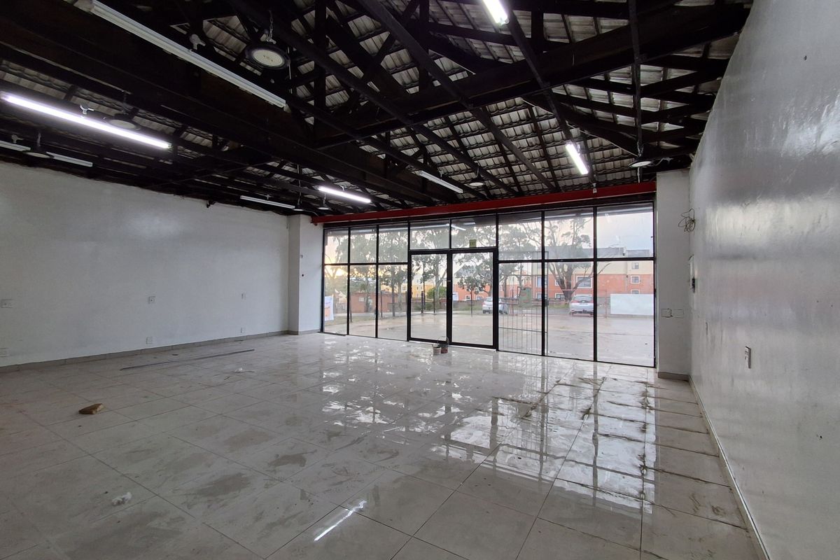 Spacious open-plan retail unit featuring high exposed timber ceilings, tiled flooring, and a large glass storefront providing excellent natural light and visibility.