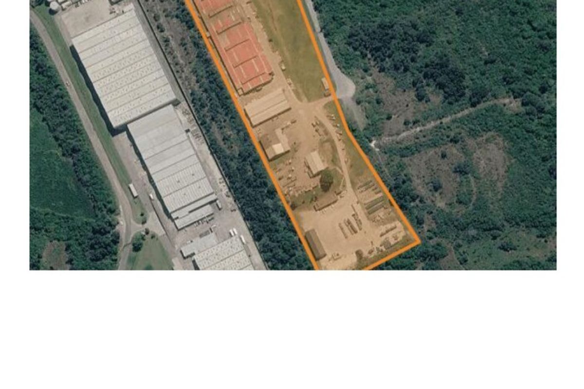 Aerial view of an industrial property featuring multiple warehouse structures, open yard space, and perimeter access within a landscaped industrial zone.