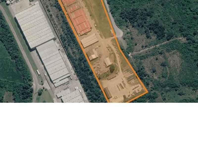Aerial view of an industrial property featuring multiple warehouse structures, open yard space, and perimeter access within a landscaped industrial zone.