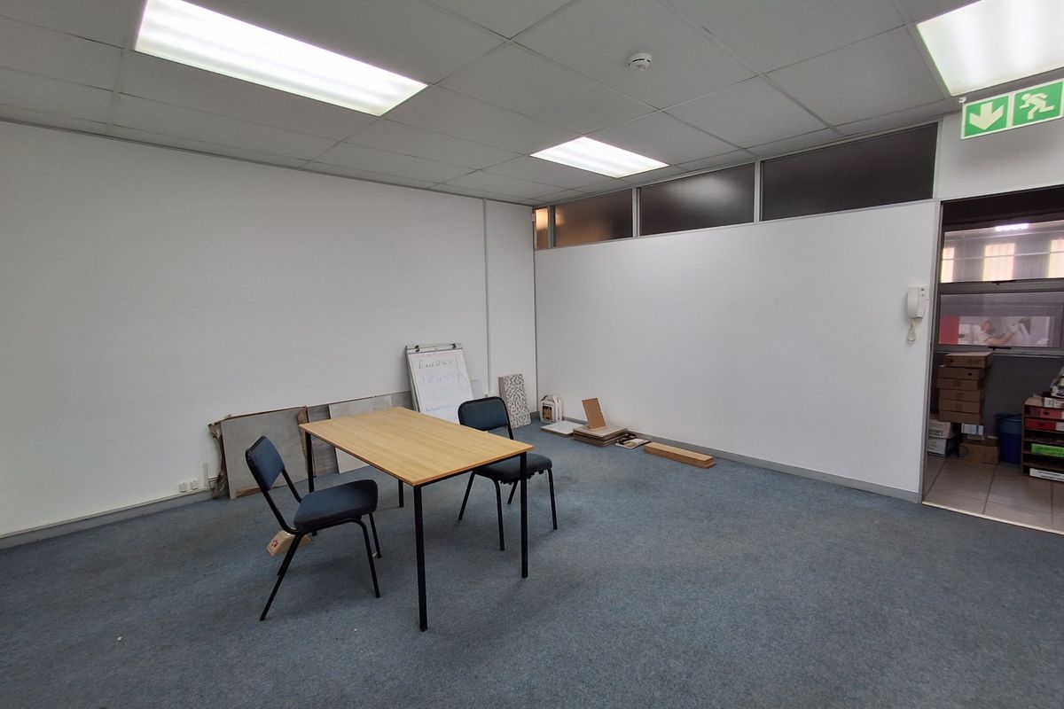 A vacant office space featuring a suspended ceiling with recessed lighting, carpeted flooring, and an intercom system, suitable for a professional workspace.