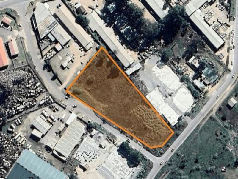 Aerial view of a vacant commercial land plot, highlighting the property boundaries within an established industrial area.