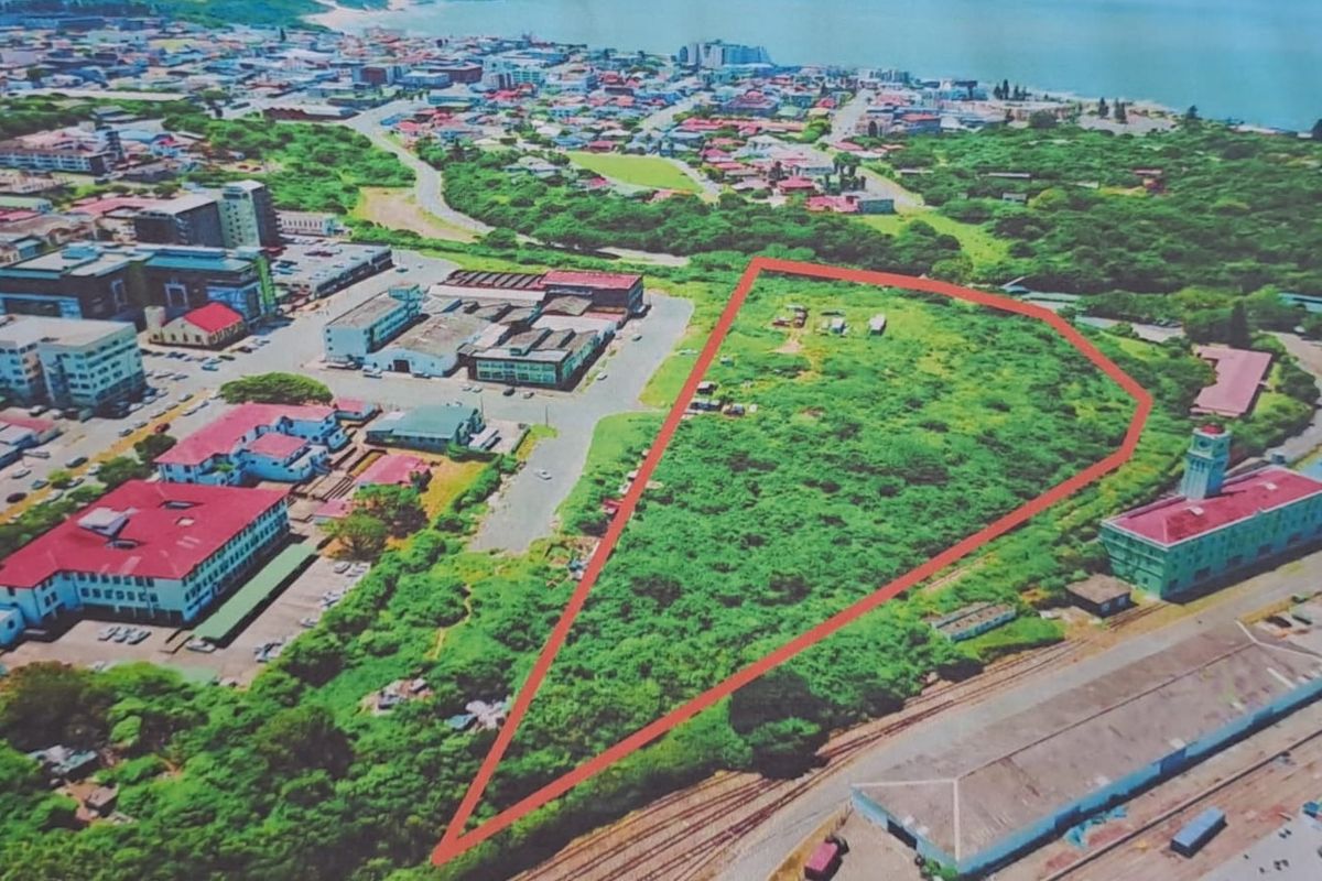 Aerial view of a large, undeveloped commercial land parcel situated within an urban environment, highlighted by a red boundary outline.