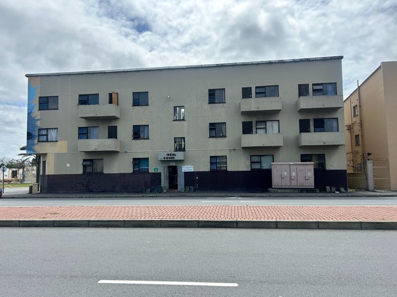 Front elevation of Ideal Court apartment building featuring multiple balconies and street-level access.
