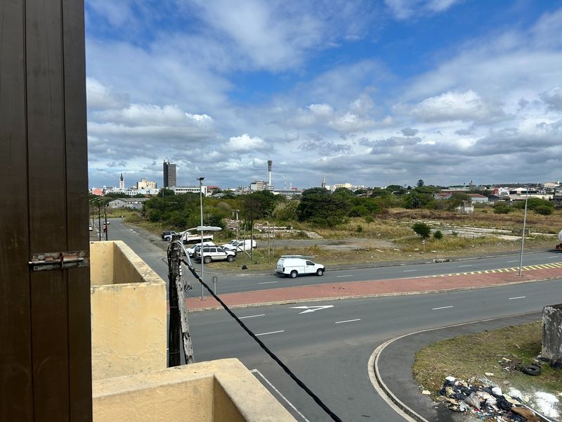 An elevated view overlooking a suburban street intersection and surrounding urban landscape from a balcony.