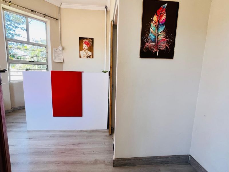 A functional entry area featuring laminate flooring, coving, and a reception desk, providing a welcoming space for guests.