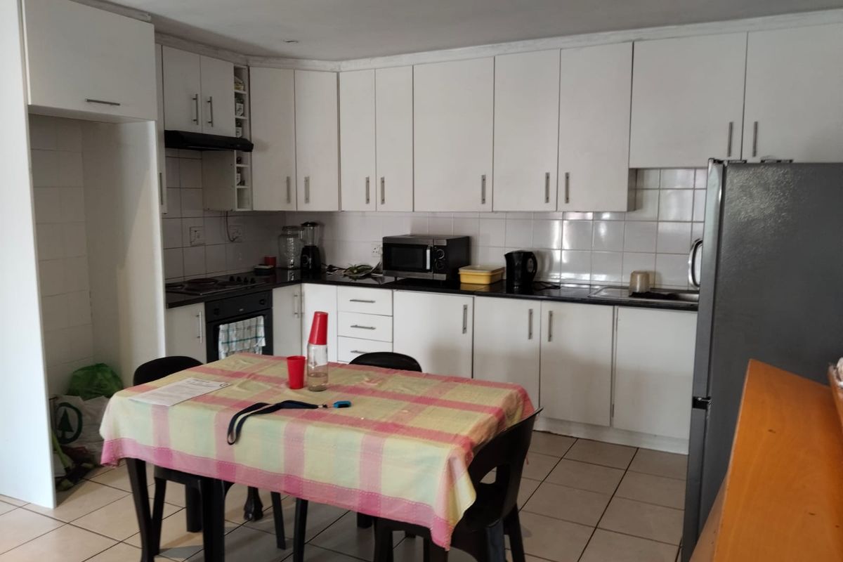 Functional kitchen featuring white cabinetry, tiled backsplash, built-in oven, hob, and ceramic floor tiles, offering a practical layout for daily meal preparation.