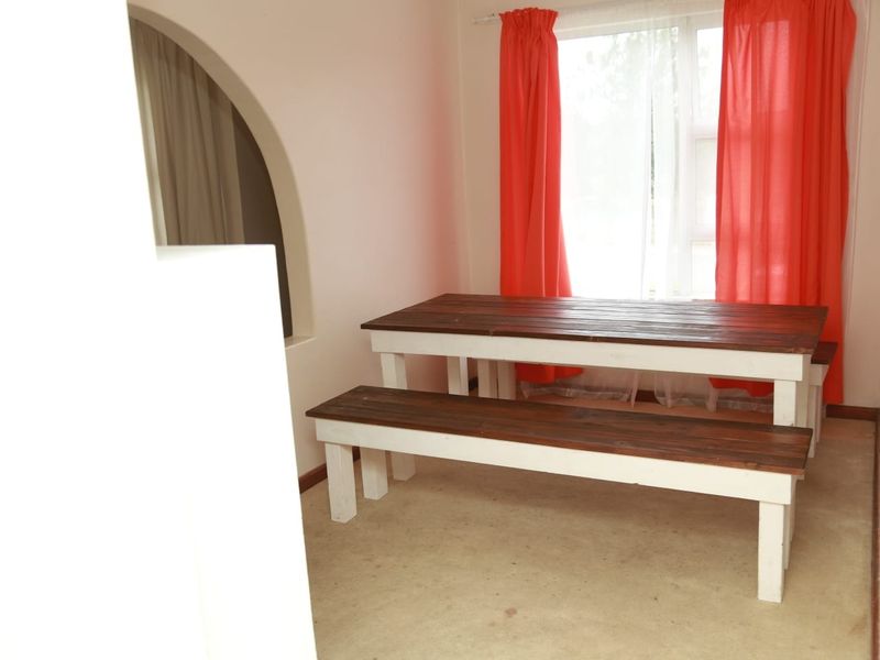 A dining area featuring a distinctive architectural archway and a window with natural light.