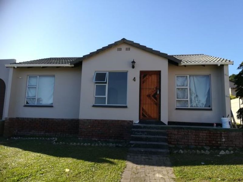 Front elevation of a single-story house featuring a tiled roof, brick base, and a secure entrance with a paved walkway.