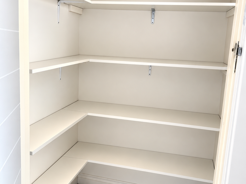 A clean, empty walk-in pantry or scullery featuring white built-in shelving and modern marble-look floor tiles.