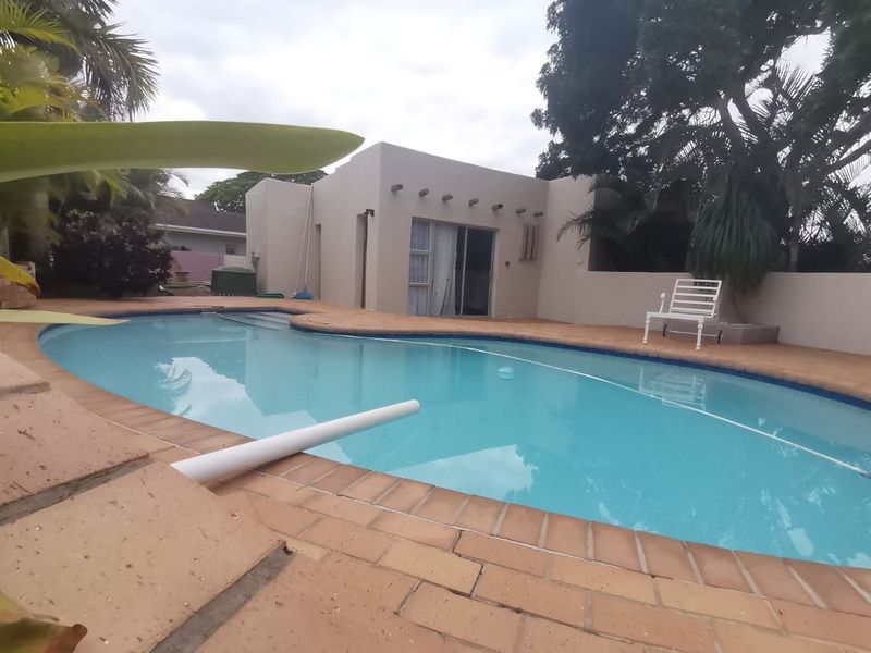 Outdoor pool area featuring a swimming pool with brick paving surround and direct access to the home via sliding glass doors.