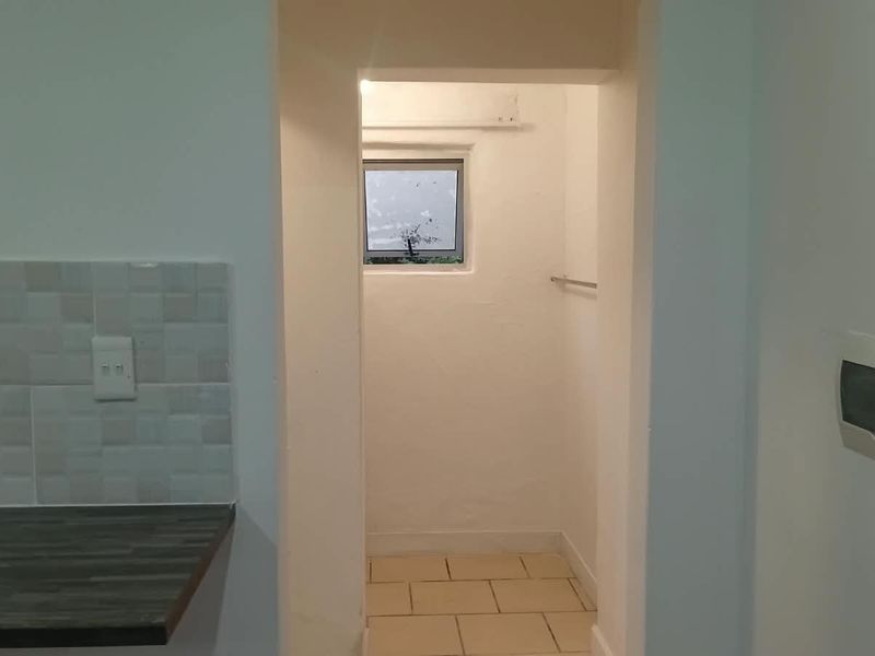 A functional scullery or utility area featuring tiled flooring, a laminate countertop, and a dedicated electrical distribution board.