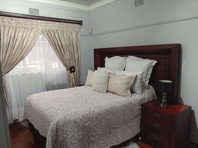 A bedroom featuring hardwood flooring and decorative crown molding, providing a classic foundation for interior updates.
