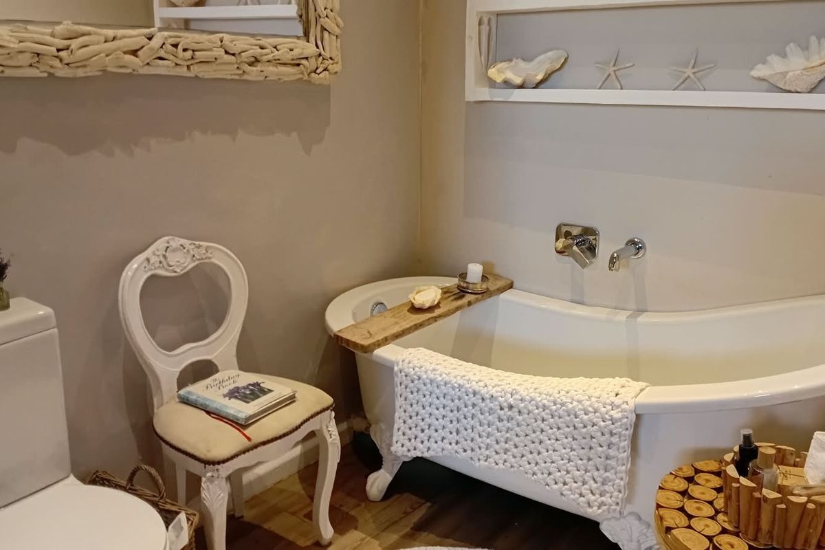 A charming bathroom featuring a classic white clawfoot bathtub with wall-mounted chrome fixtures and a convenient built-in wall niche for storage.
