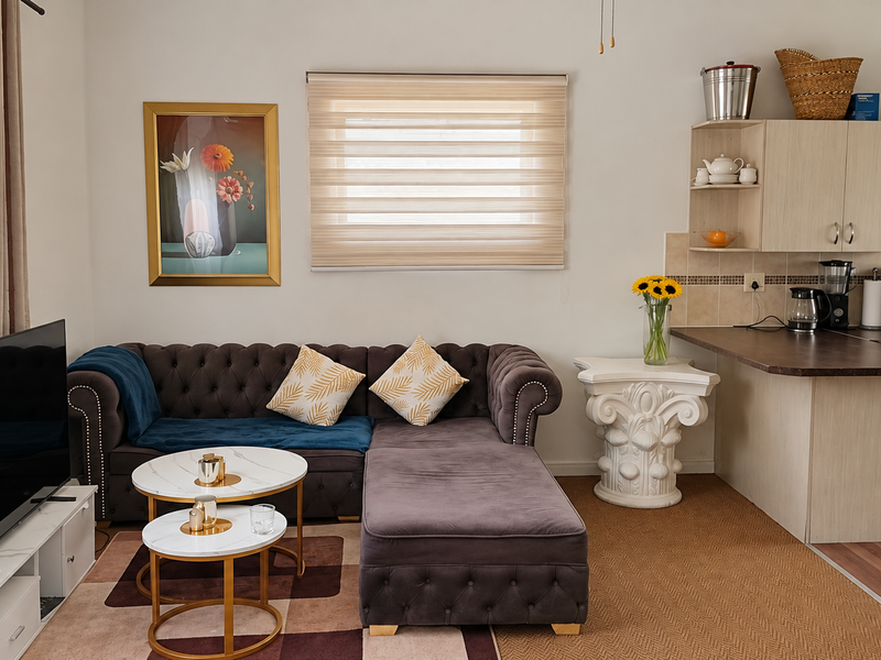 Open-plan living area featuring a functional kitchen with built-in cabinetry, laminate countertops, and a seamless transition to the lounge space.