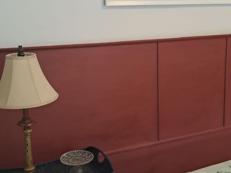 A bedroom featuring decorative wainscoting on the wall, providing a classic architectural detail to the space.