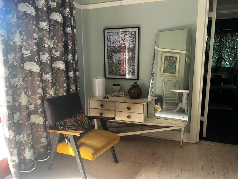 A living area featuring original timber flooring and classic crown molding, offering a character-filled space with potential for modern updates.