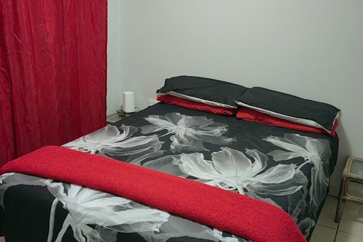 A standard bedroom featuring tiled flooring and neutral wall finishes, providing a functional space for rest.