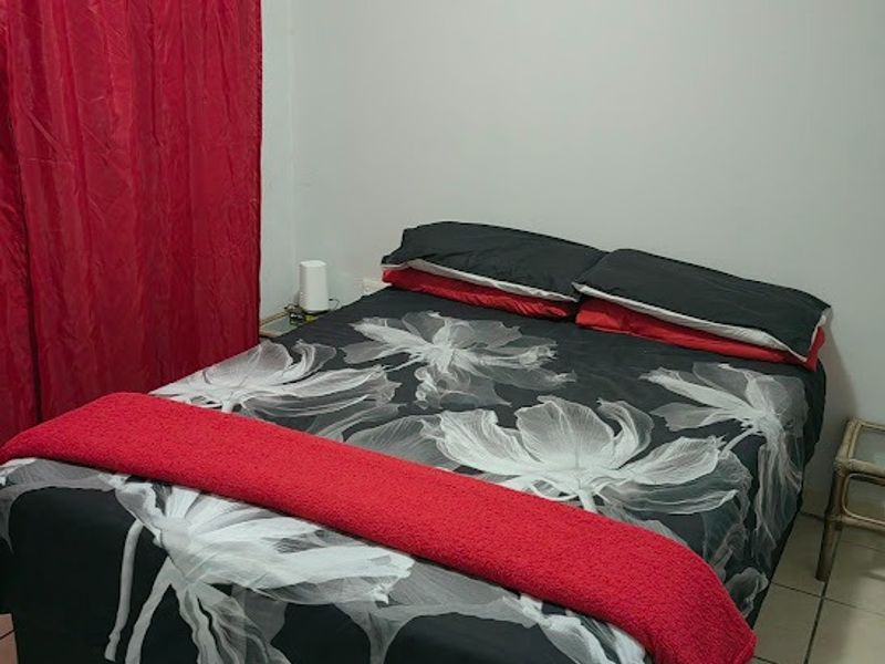 A standard bedroom featuring tiled flooring and neutral wall finishes, providing a functional space for rest.