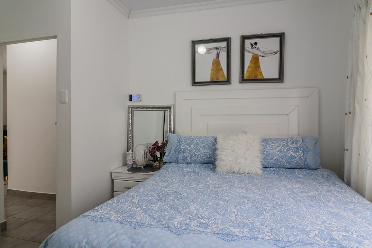 A well-maintained bedroom featuring a built-in headboard and neutral finishes, providing a comfortable and functional sleeping space.