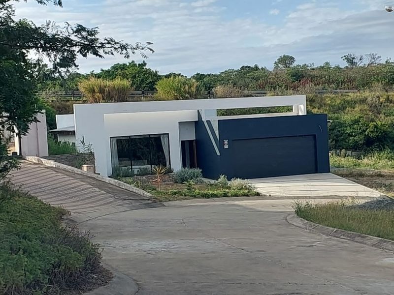 Modern single-story residential property featuring a contemporary facade, integrated double garage, and paved driveway, set within a landscaped estate environment.