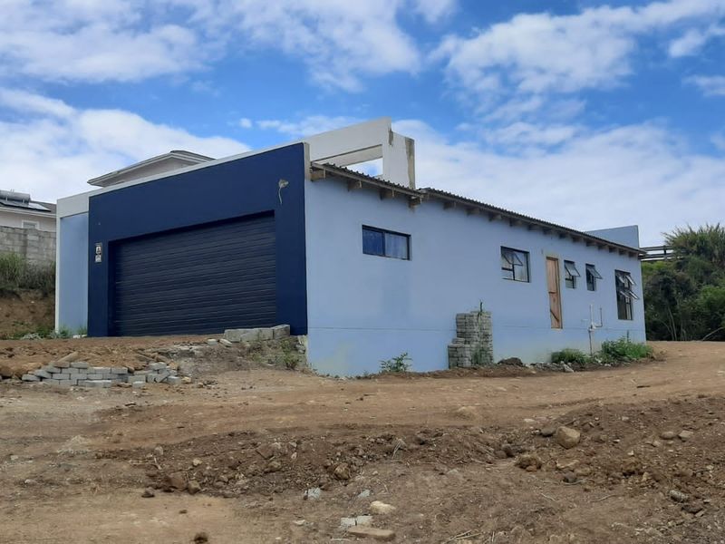Exterior view of a residential property featuring a garage and unfinished landscaping, showing ongoing construction or exterior maintenance requirements.