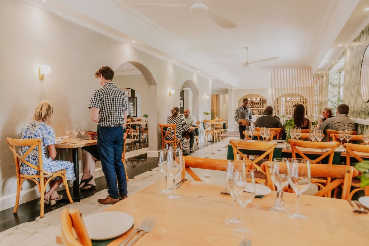 A well-appointed dining area featuring arched architectural transitions, recessed ceiling lighting, and elegant tiled flooring, suitable for a high-end hospitality or residential space.