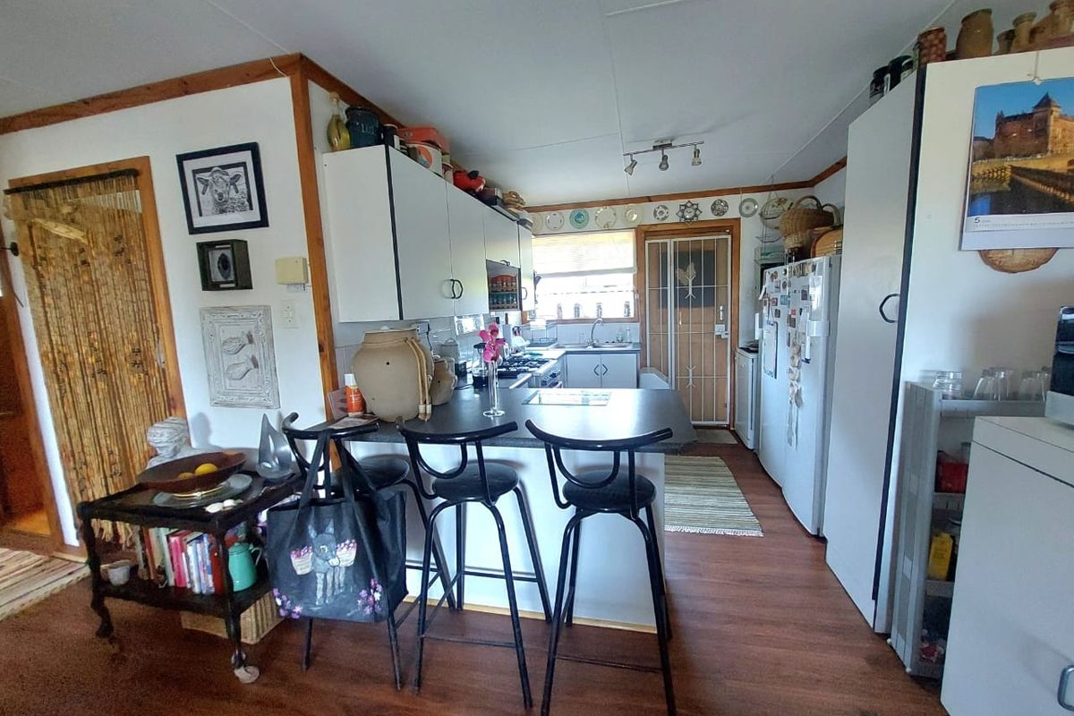 A functional kitchen featuring a breakfast bar, built-in cabinetry, and laminate flooring, providing a practical layout for daily meal preparation.