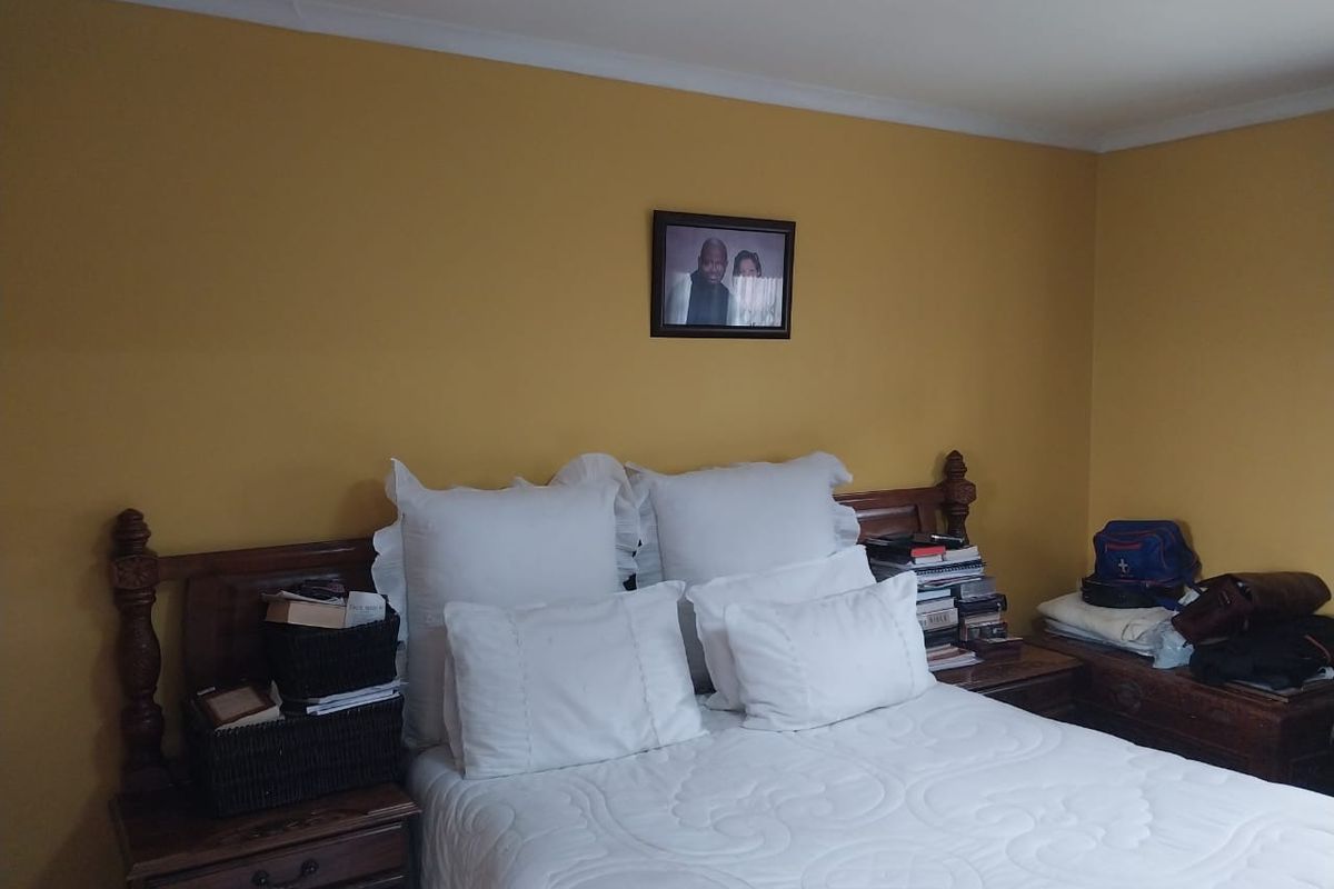 A bedroom featuring mustard-colored walls and crown molding.