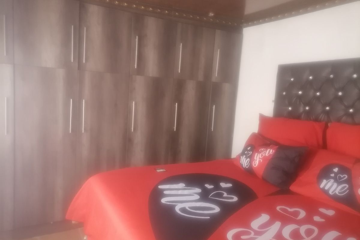 Bedroom featuring extensive built-in dark wood-grain cabinetry providing ample storage space.