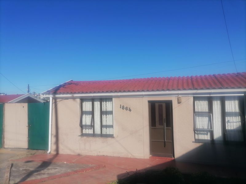 Front elevation of a single-story house featuring a red corrugated roof, aluminium window frames, and a secure entrance door.