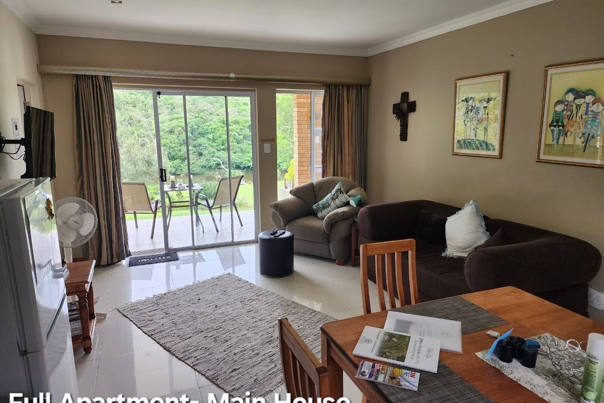 A comfortable living area featuring tiled floors and large sliding glass doors that provide natural light and access to the outdoor patio area.