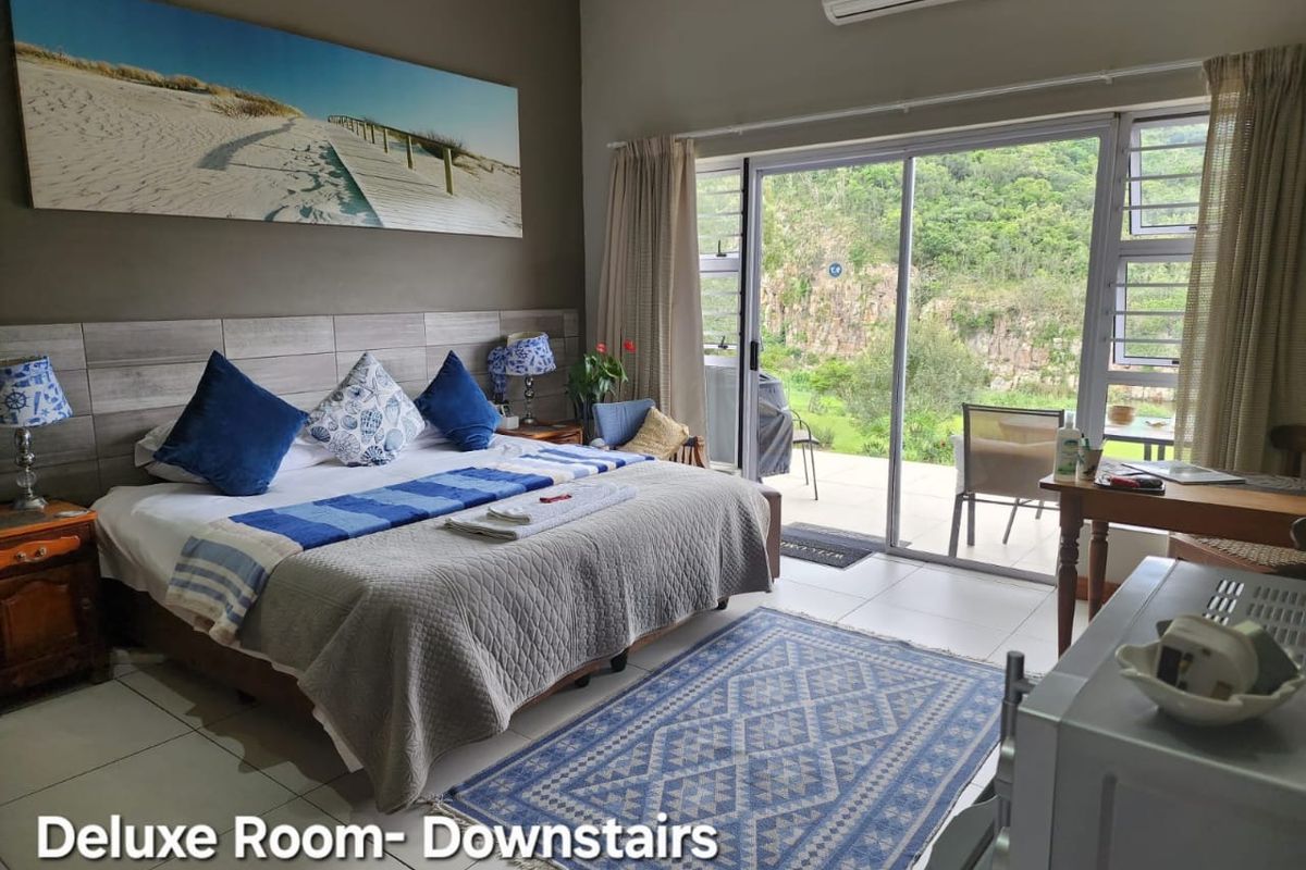 A comfortable bedroom featuring tiled floors, a wood-look headboard, and a large sliding glass door providing direct access to an outdoor patio area.