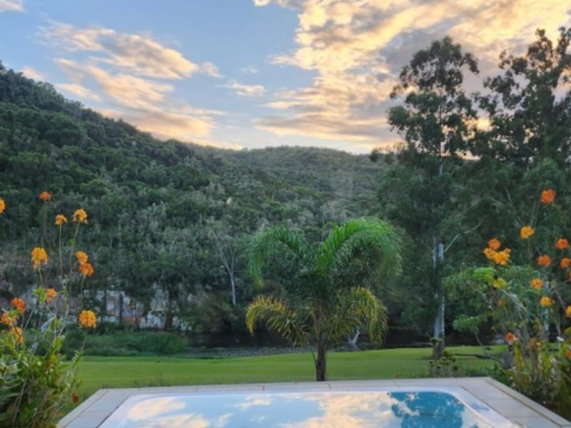 A serene outdoor spa area featuring a built-in pool with scenic views of the surrounding hills and lush landscape.