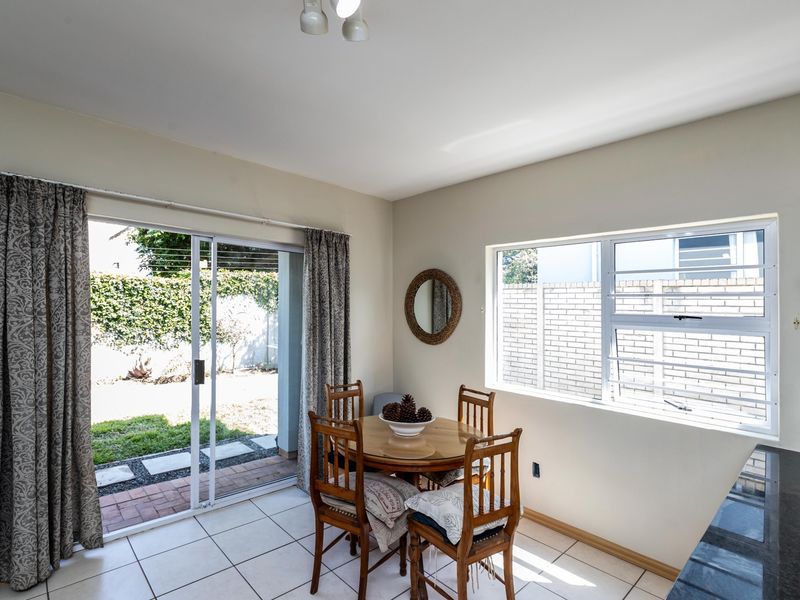 Open plan dining area featuring tiled floors, a granite countertop, and a sliding glass door providing direct access to the rear garden.