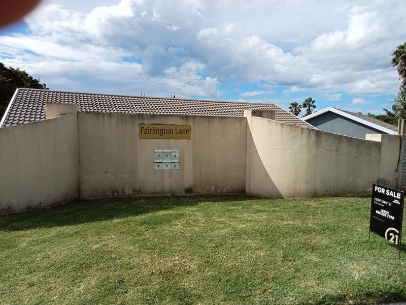 Exterior view of the complex boundary wall at Fairlington Lane, featuring a tiled roof section and communal post boxes.