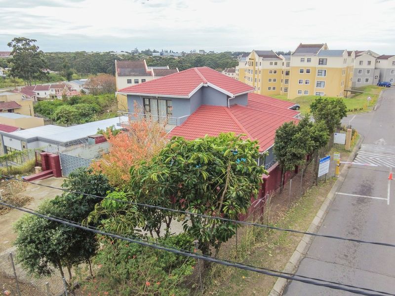Aerial view of the property showing the house structure, tiled roof, and surrounding residential estate grounds with access control.