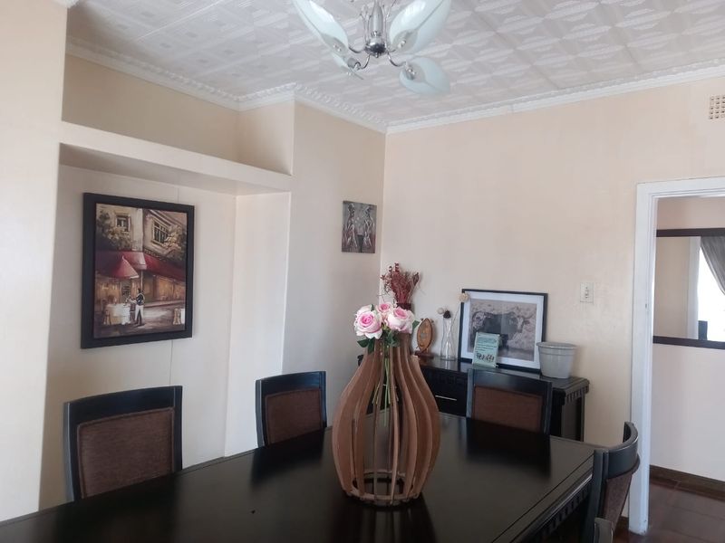 A dining room featuring decorative ceiling tiles, crown molding, and a built-in alcove, providing a classic foundation for a formal dining space.