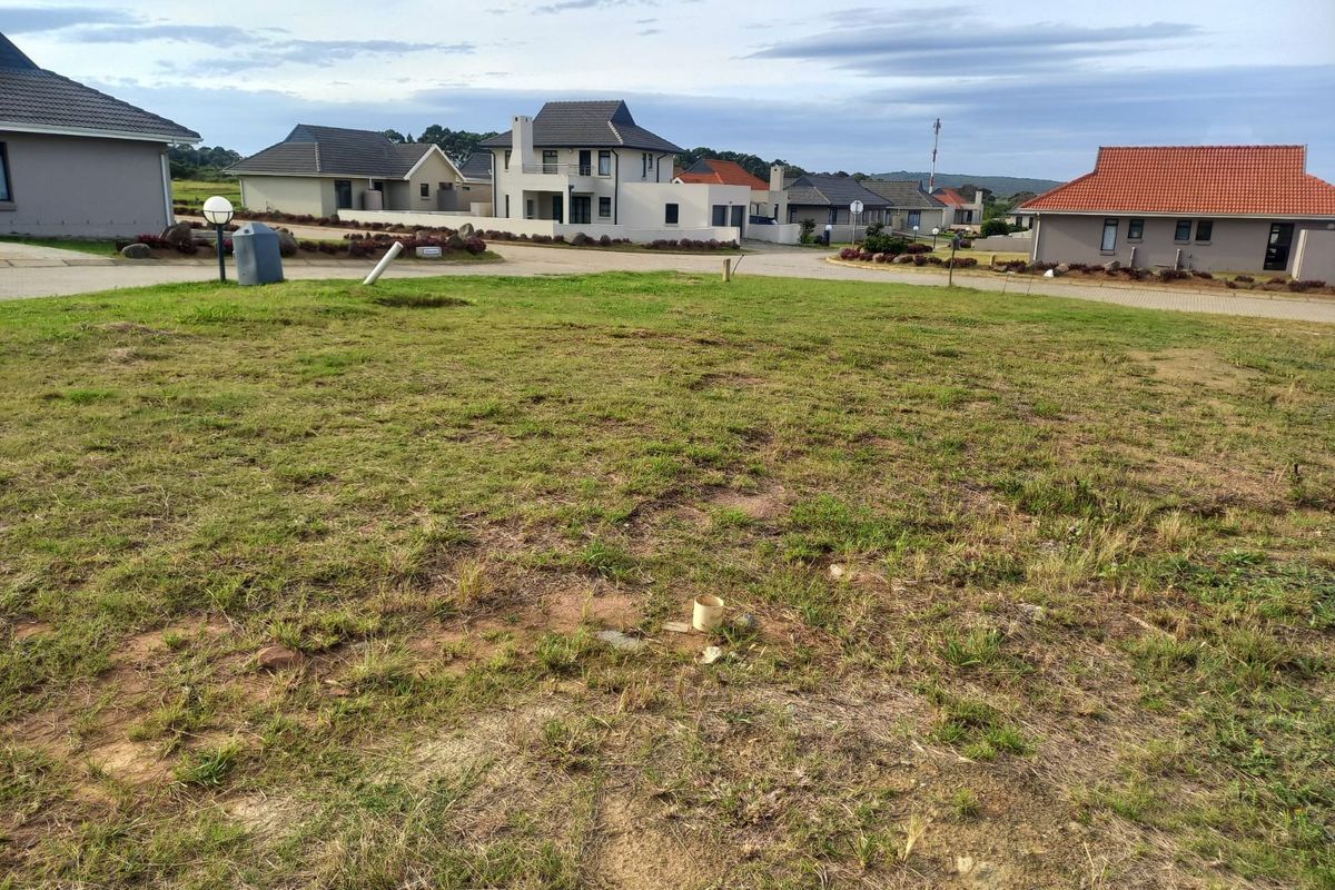 A vacant residential plot of land situated in a developed estate, featuring established surrounding homes and street access.