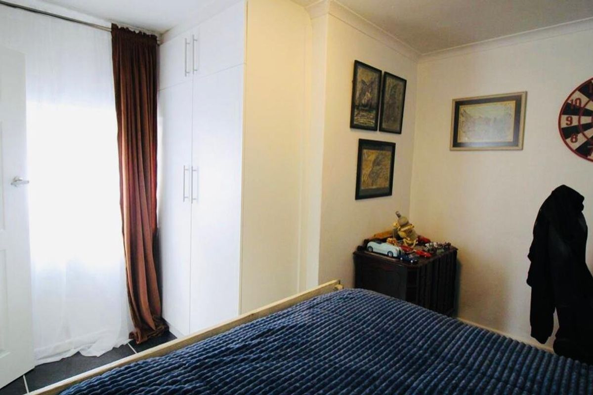 A bedroom featuring a built-in wardrobe and coving, providing functional storage and classic architectural detailing.