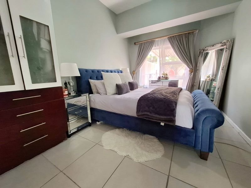 A well-maintained bedroom featuring tiled flooring and a built-in wardrobe, offering a comfortable and functional living space.