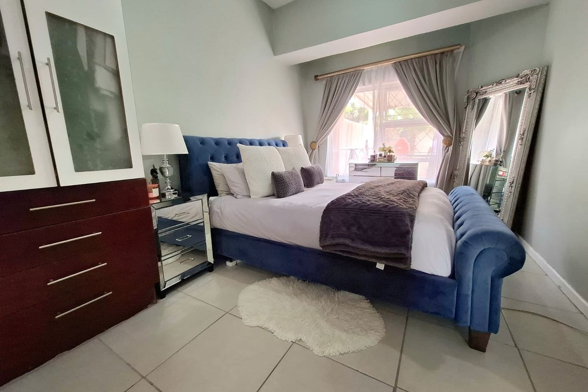 A well-maintained bedroom featuring tiled flooring and a built-in wardrobe, offering a comfortable and functional living space.